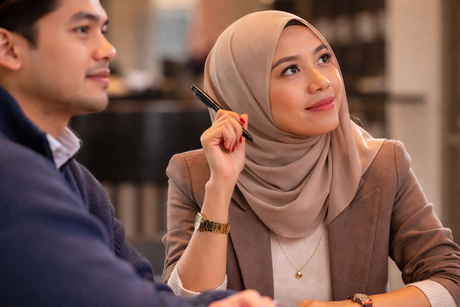 Woman in a blue sweater looking attentively at a man during a conversation